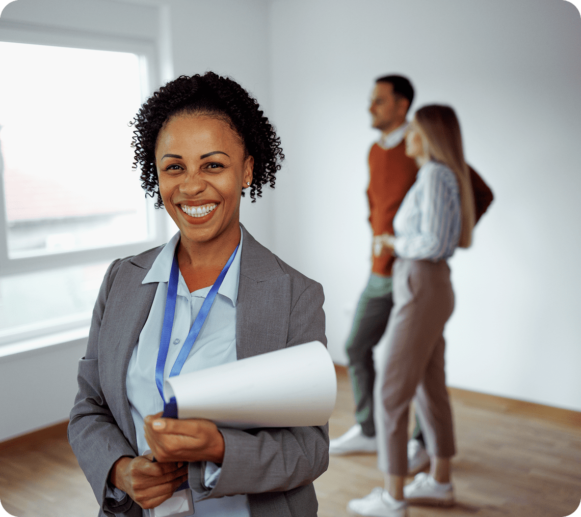 Smiling woman holding plans in office.