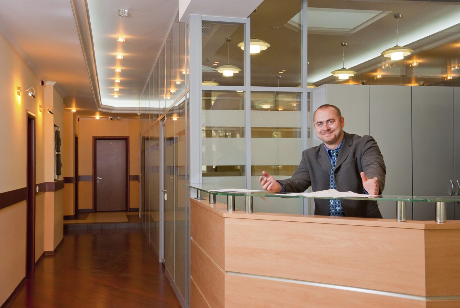 Man standing at modern office reception desk.