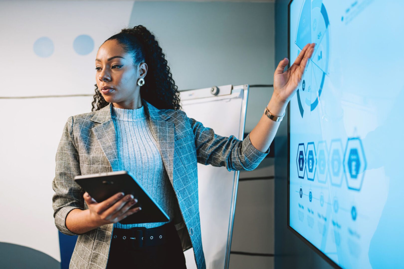 Woman presenting data on interactive screen.